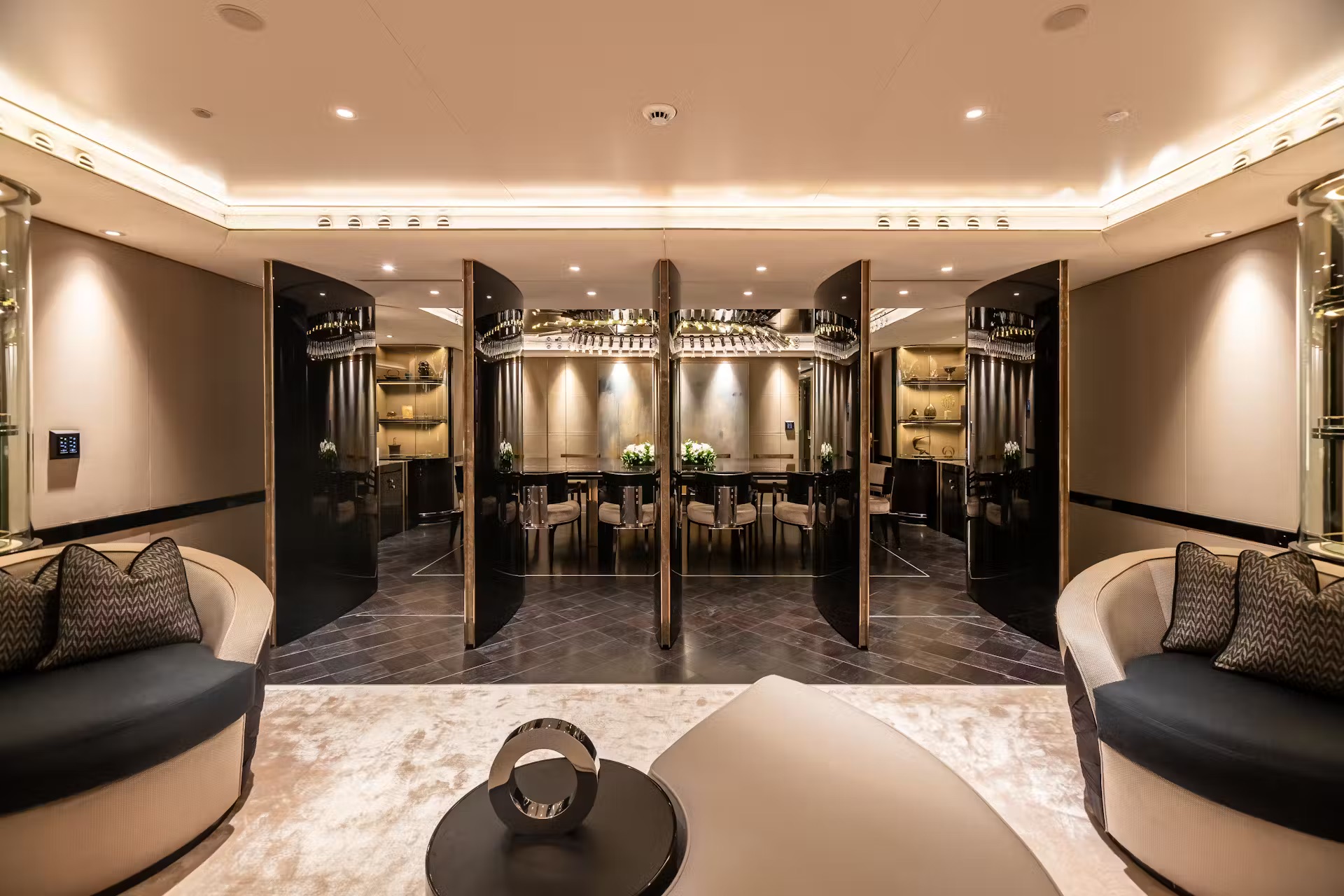 Luxury spa lounge with black marble walls, mirrored vanities, champagne display shelving and cream seating.