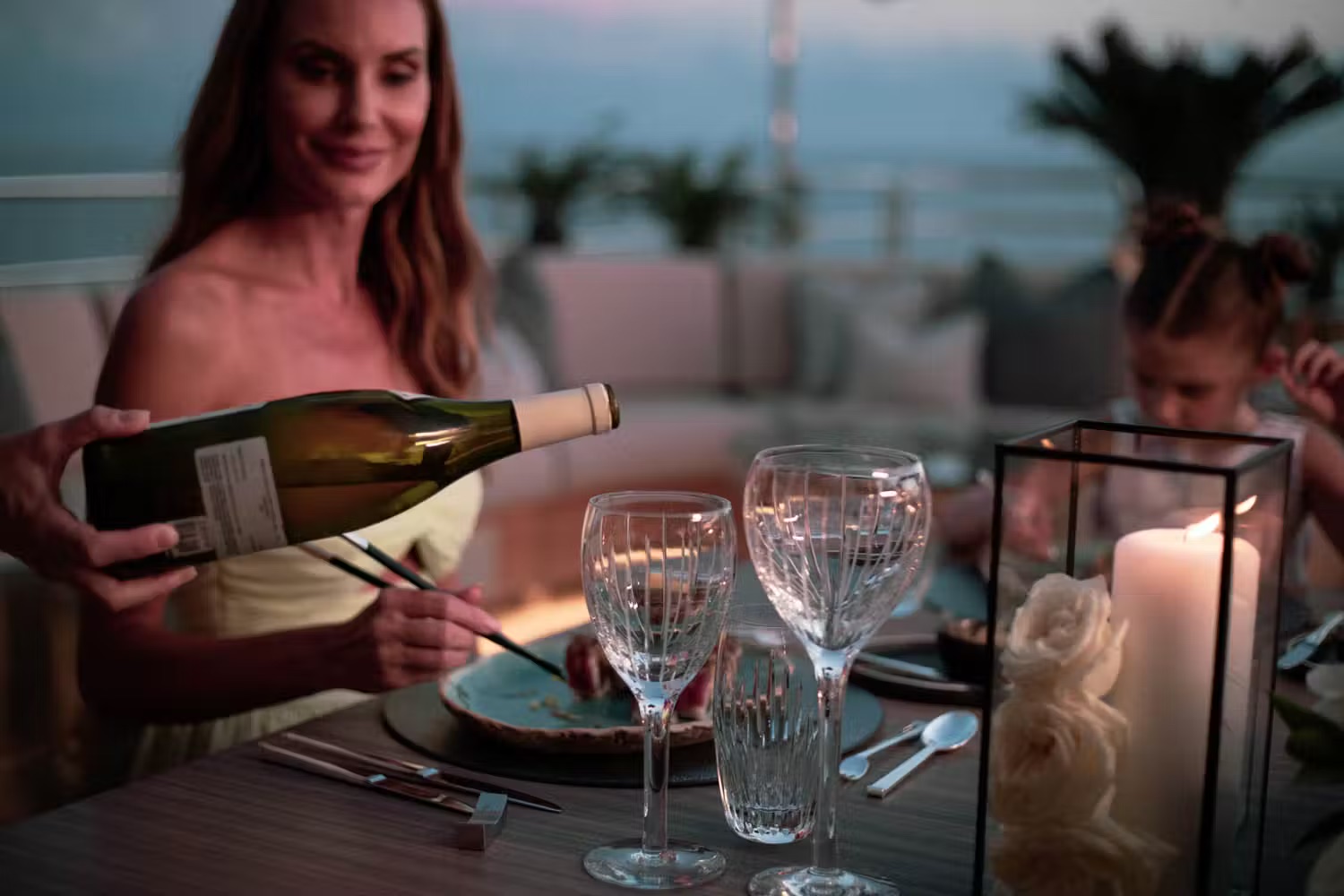 Owner's lounge aboard superyacht with contemporary seating, flower arrangement, warm accent lighting, panoramic sea-view windows.