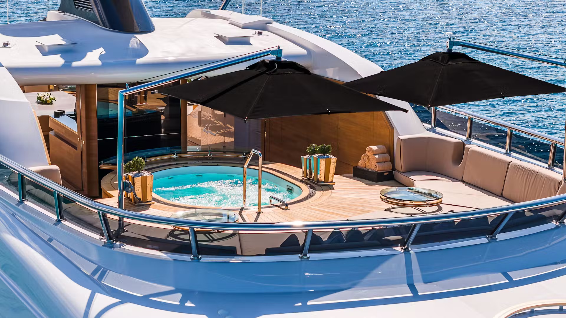 Midship heated spa pool with lounge seating, palm plants, and umbrellas