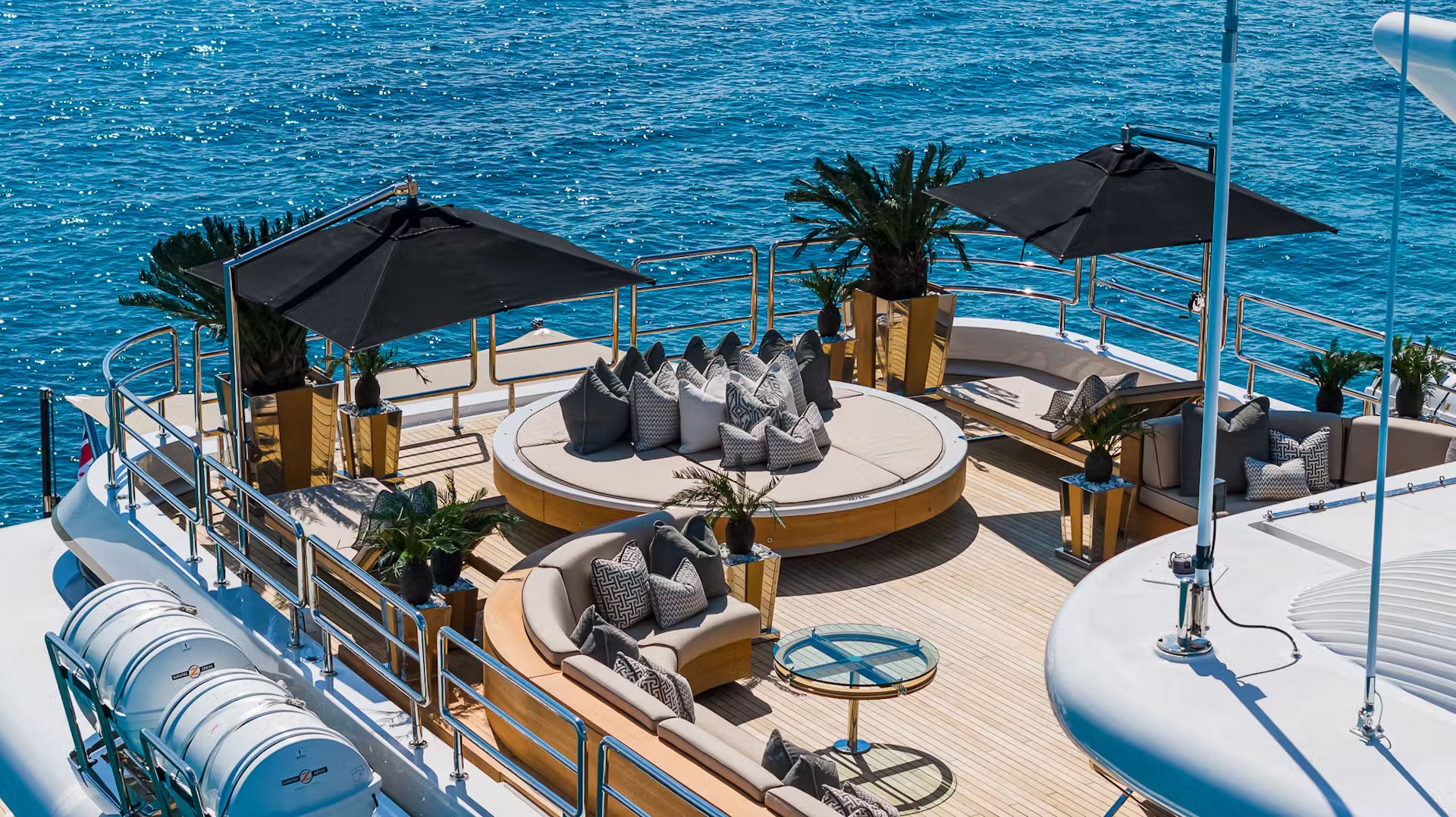 Circular deck seating area with cushioned lounges, umbrellas, and railings
