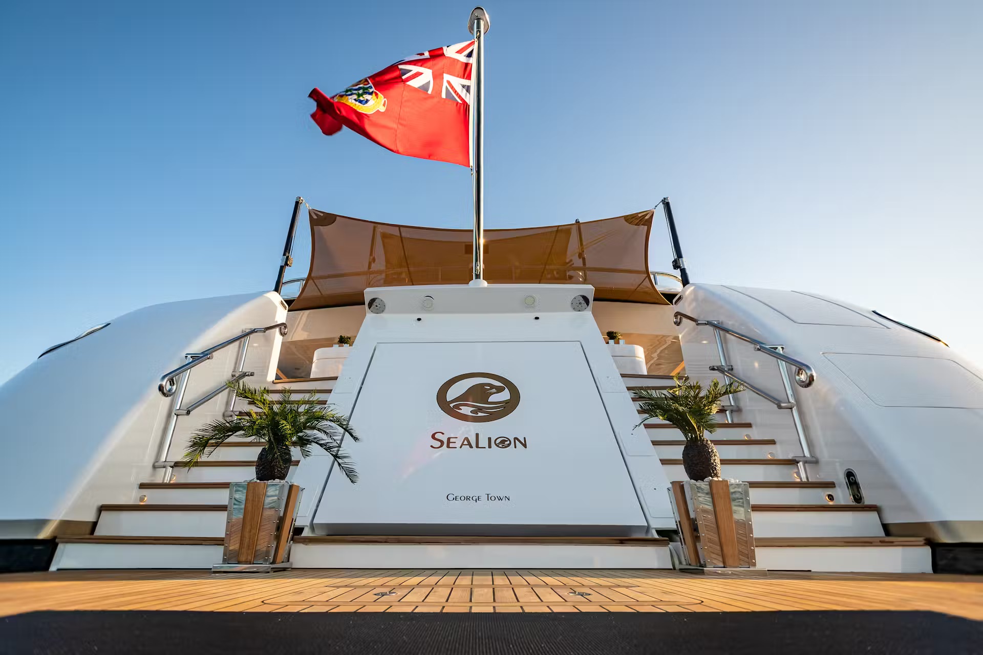 Sealion stern platform with Union Jack flag, white hull, potted palms, and George Town nameplate visible.