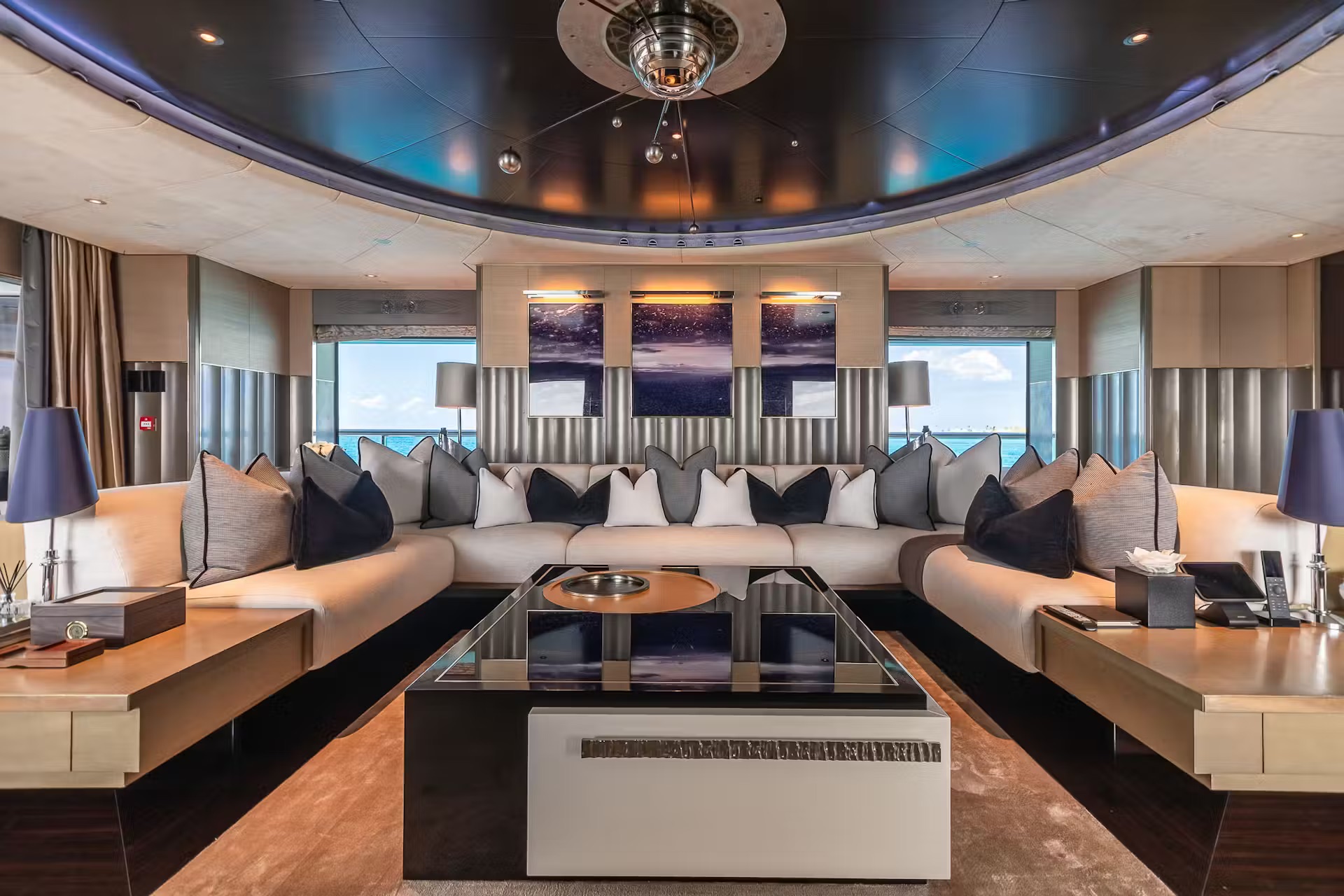 Main saloon with arched blue-lit ceiling, cream seating, and panoramic sea views