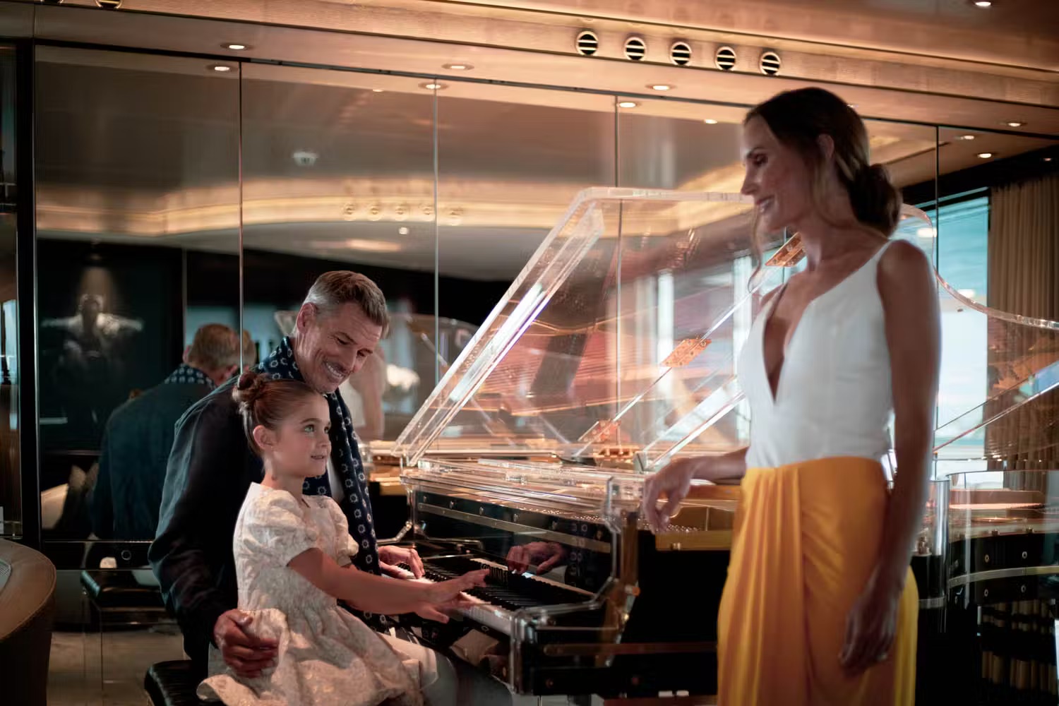 Father and daughter playing grand piano in main saloon with panoramic ocean views