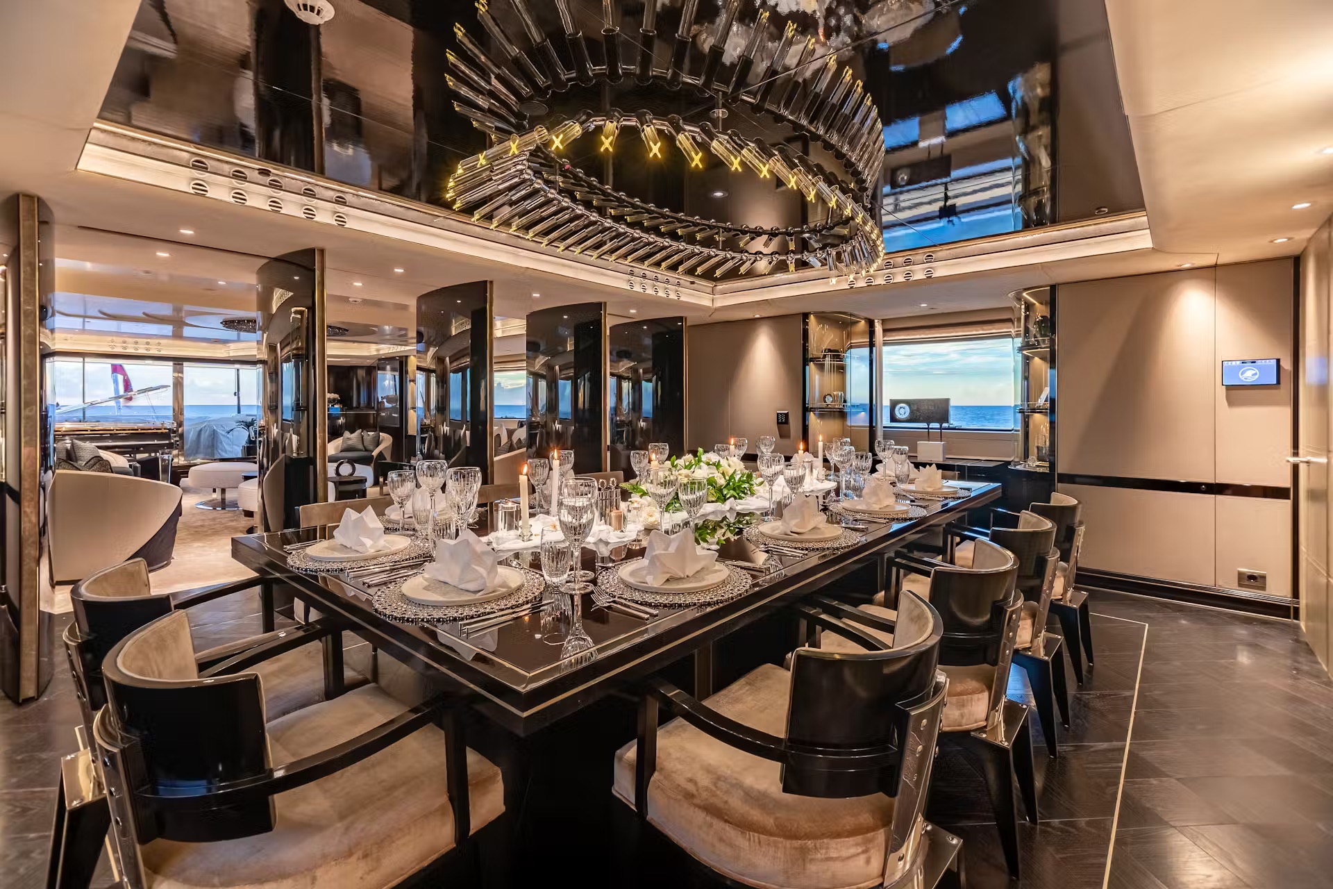 Formal dining salon with black table, sculptural ceiling, and ocean horizon views